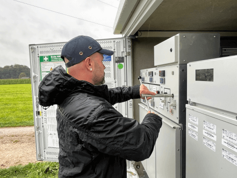 Techniker prüft Schaltanlage im Außenbereich einer Trafostation.